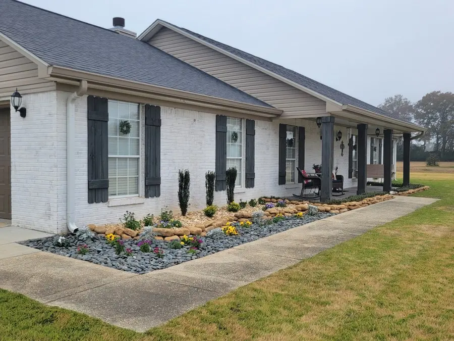 Home with fresh rock beds and trimmed lawn